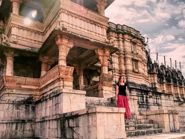 Eine Frau steht vor den imposanten Treppen der Festung Kumbhalgarh.