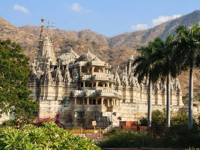 A grand, intricately carved stone temple set against a mountainous backdrop.