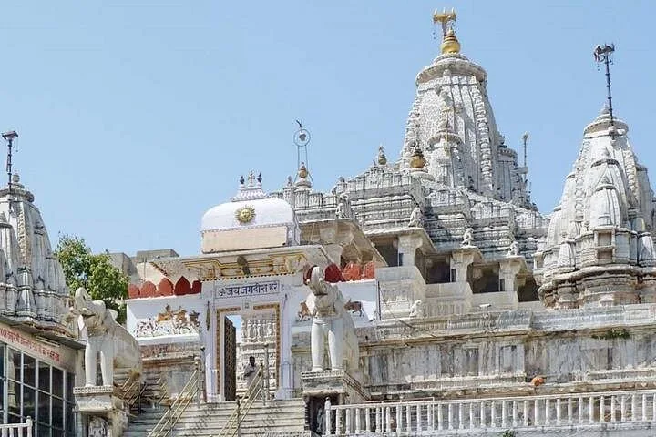 An ornate white marble temple complex with detailed carvings and domes.